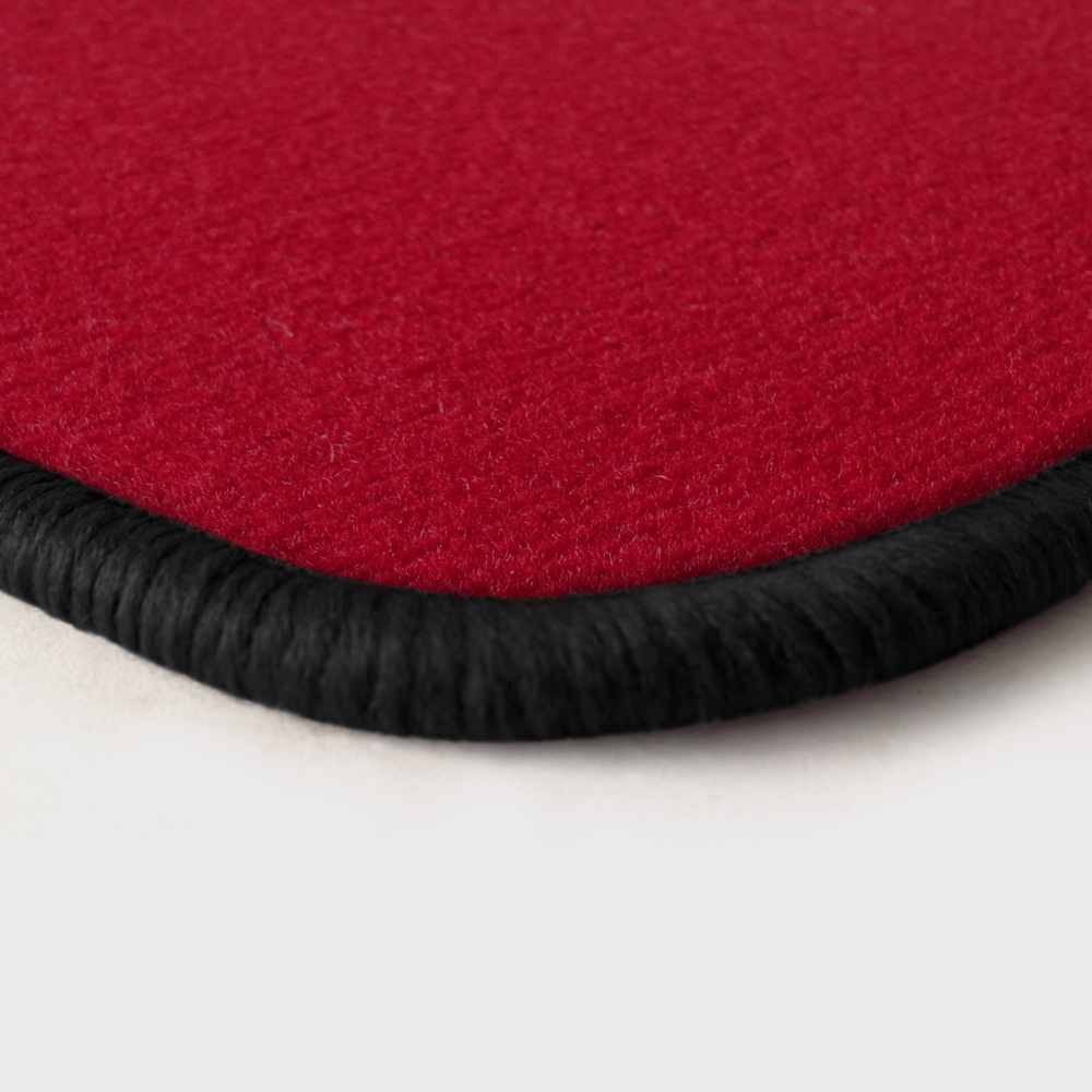 Eine Ecke als Beispiel einer Fussmatte Velours rot mit Rand in schwarz.